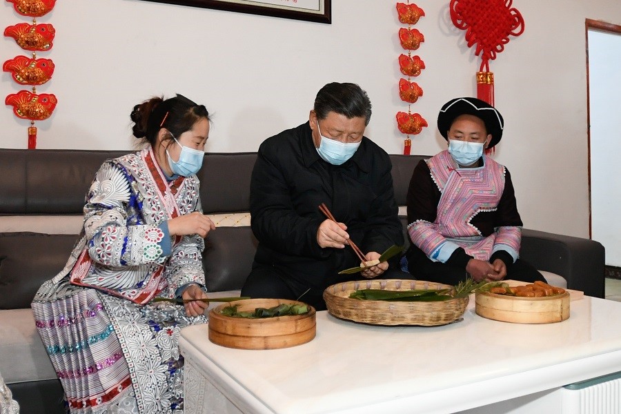 2021年2月3日下午，習(xí)近平在貴州畢節(jié)市黔西縣新仁苗族鄉(xiāng)化屋村苗族村民趙玉學(xué)家，同一家人邊聊家常邊制作當(dāng)?shù)貍鹘y(tǒng)節(jié)日食品黃粑。新華社記者 李學(xué)仁 攝